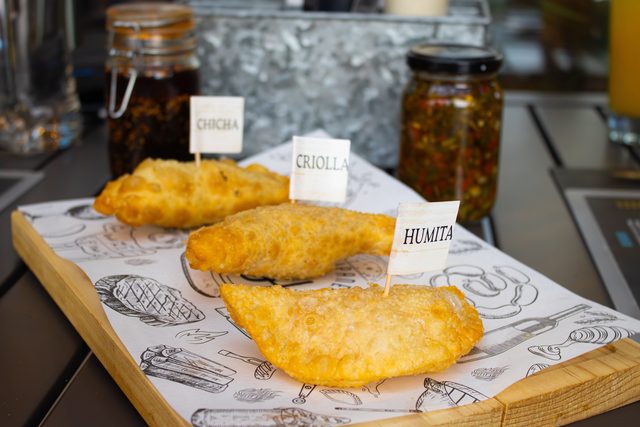 Tres empanadas con carteles de sabor